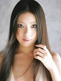 Maki Miyamoto cleavage exposed as she poses in a low cut dress